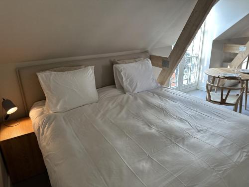迪温特Luxe Loft in Historisch Pand in Walstraat Deventer的一张带白色床单和枕头的床