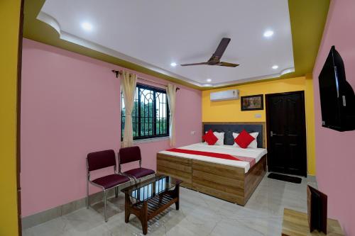 加尔各答Hotel Mahal And Restaurant Kanchrapara的一间卧室配有一张床和两把椅子