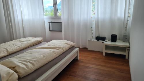 库尔Vesmira_1的配有白色窗帘和窗户的客房内的两张床