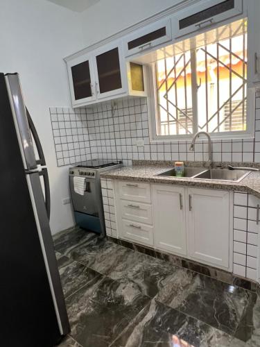 卡布雷拉City suite Apartment 1 Cabrera的厨房配有白色橱柜和黑色冰箱。
