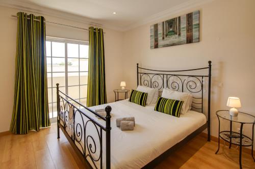 阿尔布费拉Private Deluxe 3BD Villa Pool Wi-Fi AC BBQ的一间卧室配有带绿色窗帘的黑色床