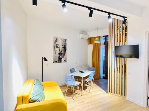 第比利斯Mohika Aparthotel的客厅配有黄色的沙发和桌子