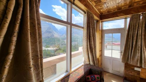 Karimabad HunzaAmn e Yal- Private Family Residence in Hunza的客房设有山景大窗户。