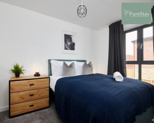 曼彻斯特Stunning 5 Bed House By PureStay Short Lets & Serviced Accommodation Manchester With Parking的一间卧室配有一张床、一个梳妆台和一扇窗户。