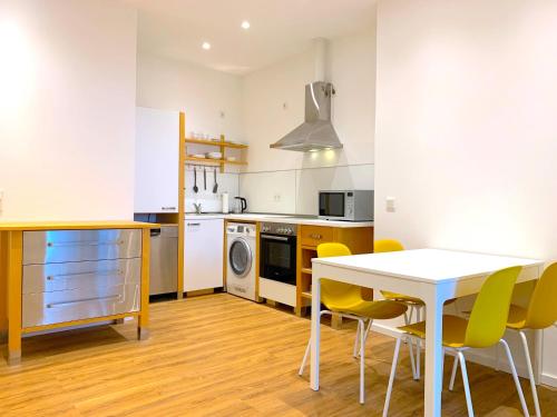 科隆Alles komplett: Zwei Schlafzimmer, große Küche, eigenes Bad的厨房配有白色的桌子和黄色的椅子