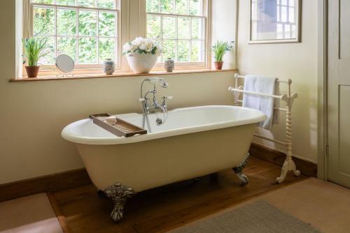 金斯布里奇The Grange的带窗户的浴室内的白色浴缸