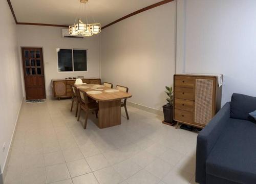 卡图Kathu Home with Mountain View的一间带桌子和蓝色沙发的用餐室