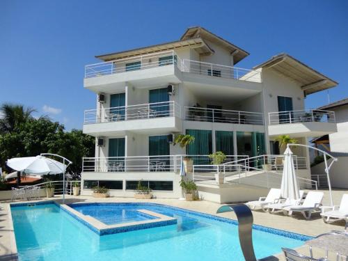 尼泰罗伊Camboinhas Beach Pousada的一座带游泳池和房子的别墅