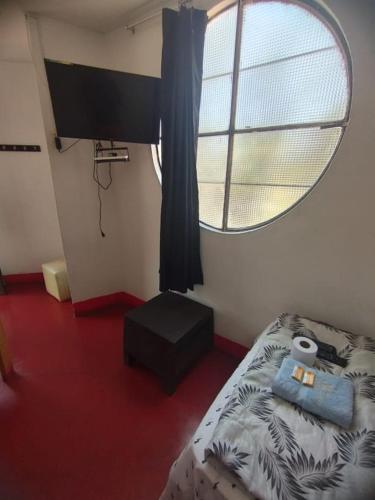 伊察Hotel Casa Sol的一间卧室设有一张床和一个圆形的窗户。