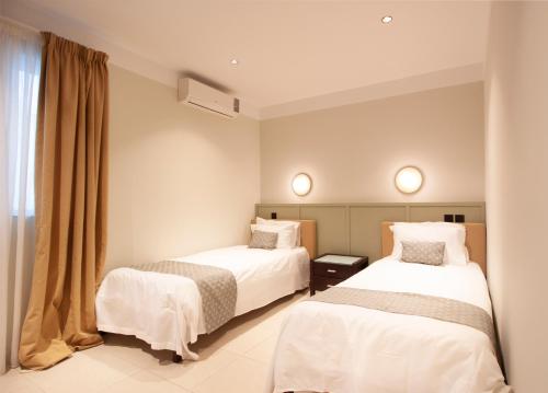 圣保罗湾城VILLA JOSEPH的酒店客房设有两张床和窗户。