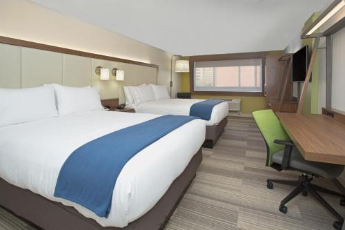 休斯顿Holiday Inn Express & Suites - Houston IAH - Beltway 8, an IHG Hotel的酒店客房配有两张床和一张书桌