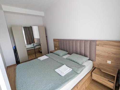 库塔伊西Brand new apartment in Kutaisi的一间卧室配有一张带绿色床单和镜子的床