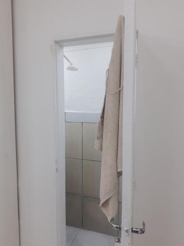 马瑙斯Hotel SIMPLE的带淋浴和毛巾的浴室,挂在门上