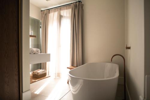 塞维利亚Legado Magdalena Hotel的带窗户的浴室内的白色浴缸