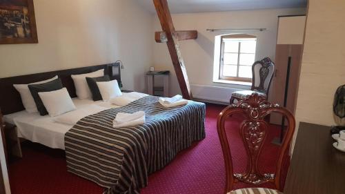 Borcz粮仓酒店的卧室配有床、椅子和窗户。
