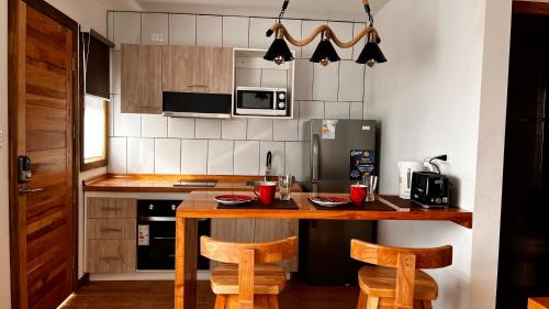 纳塔列斯港Origenes Apartments的厨房配有木桌和两把椅子
