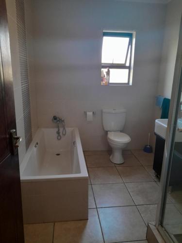 塞昆达Secunda BackPackers的带浴缸、卫生间和盥洗盆的浴室