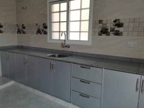 Bawsharفيلا مسقط - Muscat Villa的厨房设有水槽和窗户。
