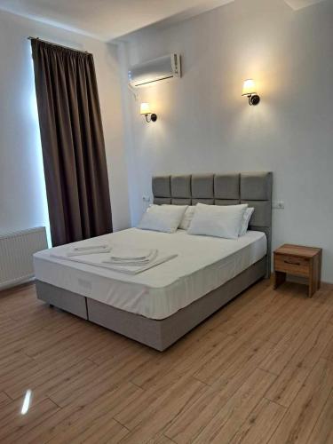 安布罗劳里Gonadze Vineyards Hotel的一间卧室配有一张带棕色窗帘的大床