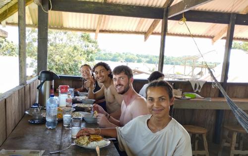 MacedoniaHospedaje y tours Reina Arriera amazonas colombia的一群坐在餐桌上吃食物的人