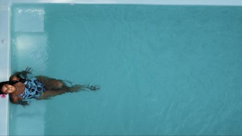 马尔多纳多港Casa Amazonas的漂浮在游泳池中的女人