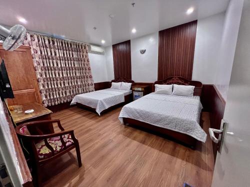 吉婆岛Tra My Hotel (Khách sạn Trà My)的一间卧室配有两张床和一张桌子及椅子