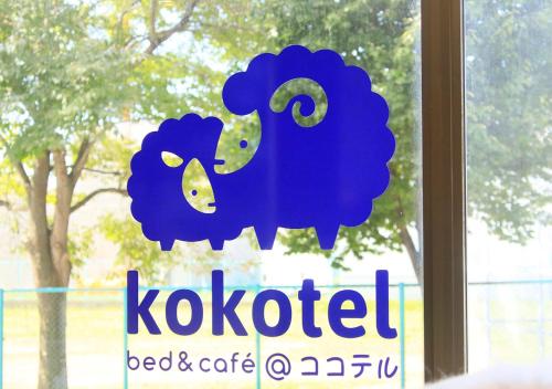 函馆Kokotel Hakodate的窗口上带有蓝色绵羊的标志