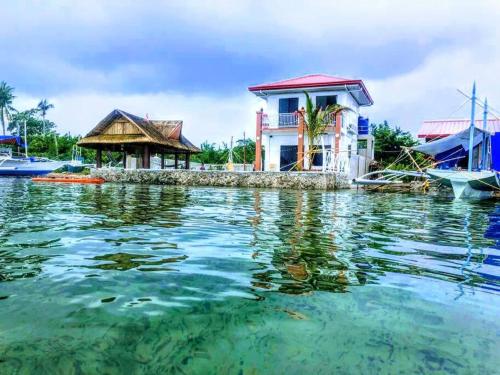Lapu Lapu CityPRIVATE COLLECTION 贅沢 Jade's Beach Villa 별장 Cebu-Olango An exclusive private beach secret的船旁水面上的房屋
