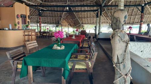 巴加莫约Funky Squids Beach Resort的一间带绿色桌椅的用餐室