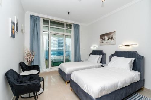 迪拜Marina Yacht Club Views - 3BR Modern Furnished的一间卧室设有两张床、一把椅子和一个窗户。