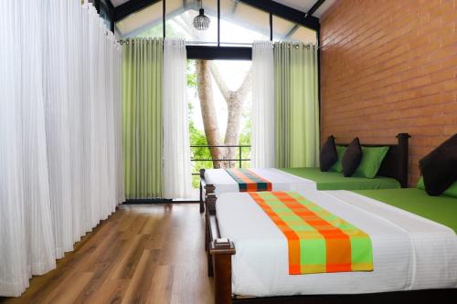 Pahala MaragahawewaLife of Leisure Wilpattu的一间卧室设有两张床和窗户。
