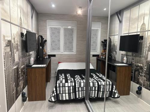 马德里Habitación New York - 5 Torres的一间卧室配有一张床和一台电视