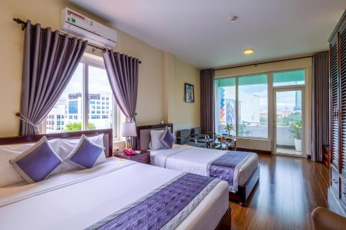 顺化Baly Hotel And Spa的酒店客房设有两张床和大窗户。