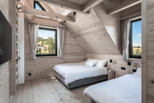 Białka TatrzanskaDom Bio - Unique Ski Chalet, Białka Tatrzańska, Slovakia, Zakopane的带2扇窗户的客房内的2张床