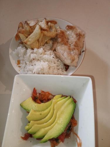 加拉加斯Como en Casa的两盘带米饭和鳄梨的白盘食物