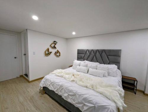 波哥大CHARMING APARTMENT IN CHICO RESERVED, 93 PARK, ZONE T!的卧室配有白色大床和白色枕头