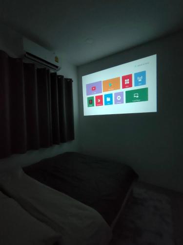 Ban Noi Pho KhamJanis Home的黑暗的房间里设有电视屏幕和床