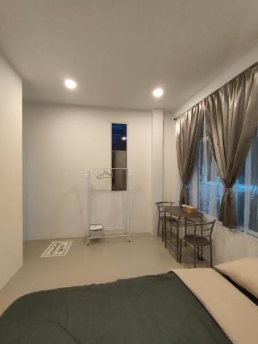 Ban Noi Pho KhamJanis Home的一间卧室配有一张床、一张桌子和一个窗户。