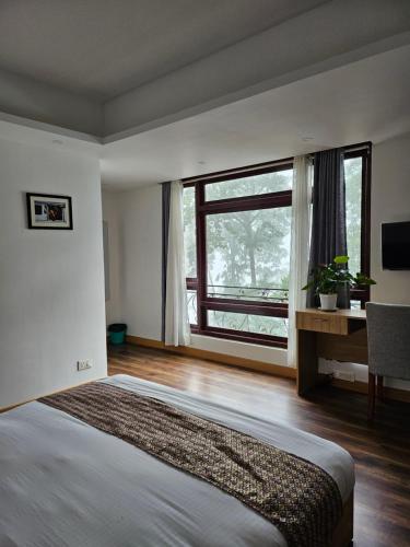 甘托克Shanol Residency的一间卧室设有一张大床和一个大窗户