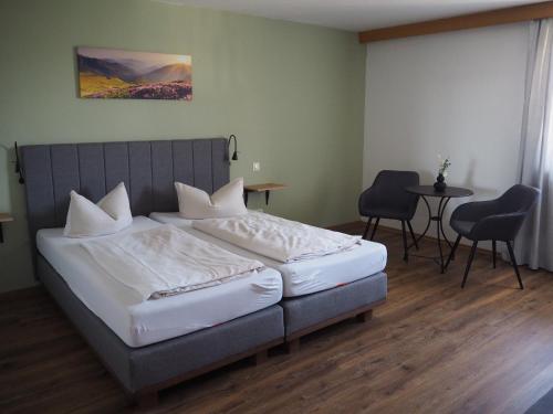 HalfingHotel Garni Kern的卧室配有一张床和一张桌子及椅子