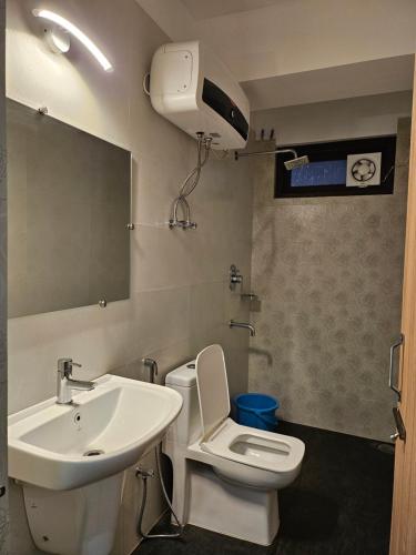 甘托克Shanol Residency的一间带水槽、卫生间和镜子的浴室
