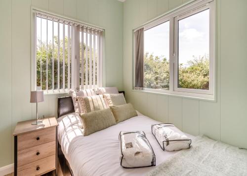 马诺比尔Calvesland Hideaway的一间卧室设有一张床和两个窗户。