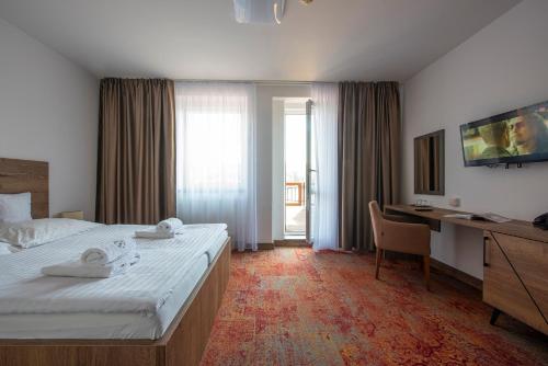维内维内健康酒店的酒店客房配有一张床和一张带电脑的书桌