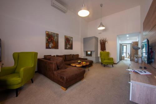 维内维内健康酒店的客厅配有棕色沙发和绿色椅子