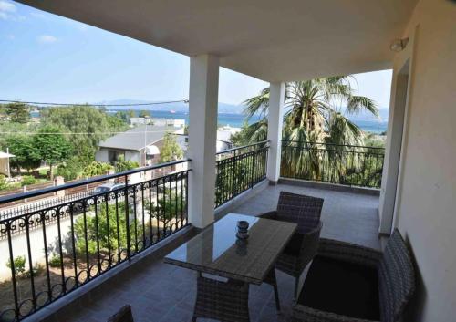 埃雷特里亚Άνετο διαμέρισμα για 4 με θέα的阳台配有桌椅,享有海景。