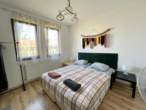 BratsigovoKassandrova Guest House & Spa的一间卧室配有一张带格子毯子和窗户的床。