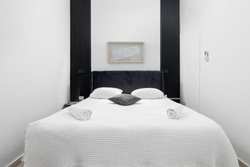 埃拉特La suite eilat的卧室配有白色的床和2个枕头