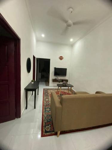大山脚Tok Abah Homestay Bukit Mertajam的客厅配有沙发和桌子