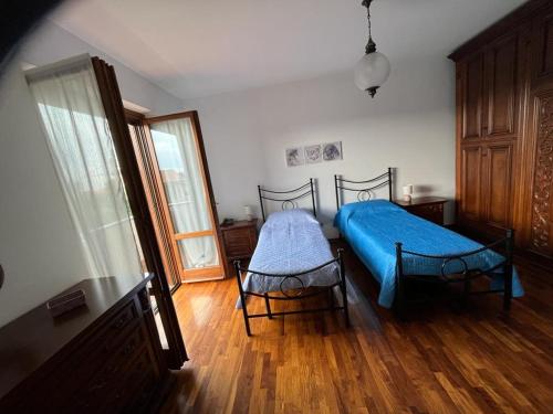 比耶拉A casa di Antonella的一间卧室设有蓝色的床,铺有木地板。