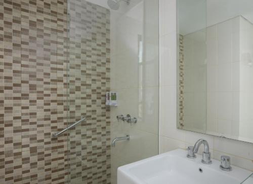 茉莉芬茉莉芬爱玛瑞丝酒店 的浴室配有盥洗盆和带镜子的淋浴